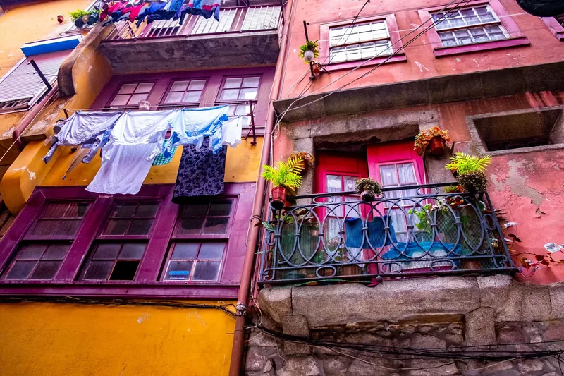 Laundry hanging on lines across colorful building facades, Porto, Portugal